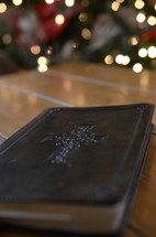 leather bound Bible on a coffee table with Christmas tree in the background 