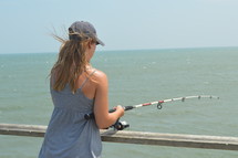 woman fishing on a pier 