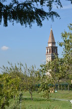 distant church steeple and orchard trees 