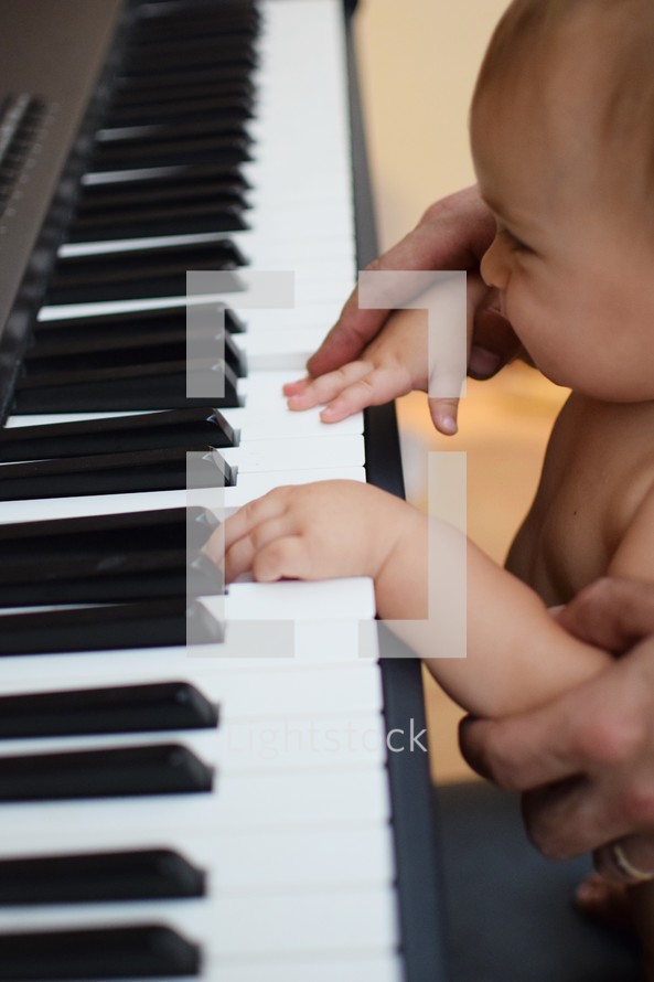 infant playing a piano 