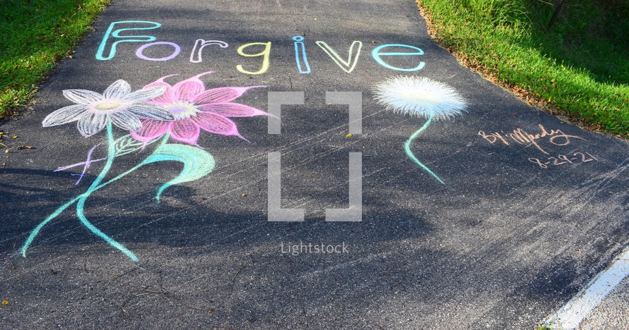 Chalk artwork on a path with the word "Forgive" and flowers