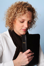 woman praying holding a Bible 
