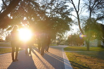 sunburst on a sidewalk and college students walking 