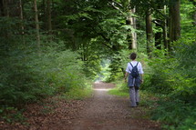 woman walking on a trail in the woods 