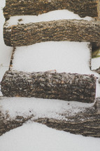 Snow covering a stack of firewood