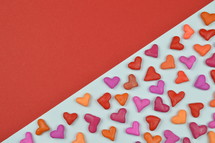 colorful heart shapes on red and white background 
