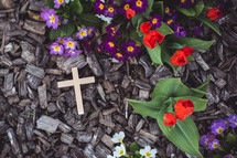 wood cross in mulch and flowers 