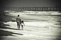 father and daughter walking on a beach 