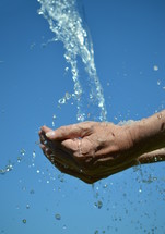water of life - water flowing from the sky into open cupped hands