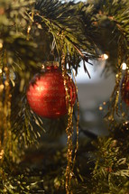 red ornament and gold tinsel on an ornament 