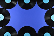 old black vinyl records with blank cyan labels on blue background as frame