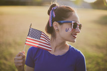 woman holding an American flag for July 4th 