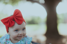 a baby girl with a red headband and bow 