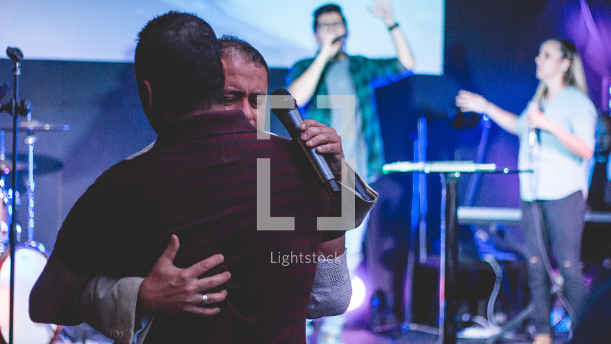 hugs on stage during a worship service 