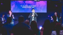 a worship leader on stage with a microphone 