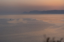 Sailing boat on calm sea while sunrise