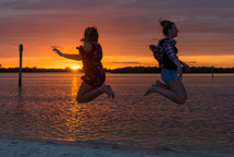 teen jumping on a beach at sunset 