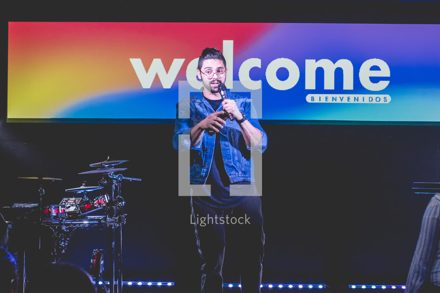 welcome sign and worship leader on stage 