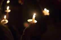 person holding a candle at a candlelight service 
