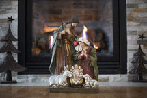 Nativity scene in front of a fireplace 