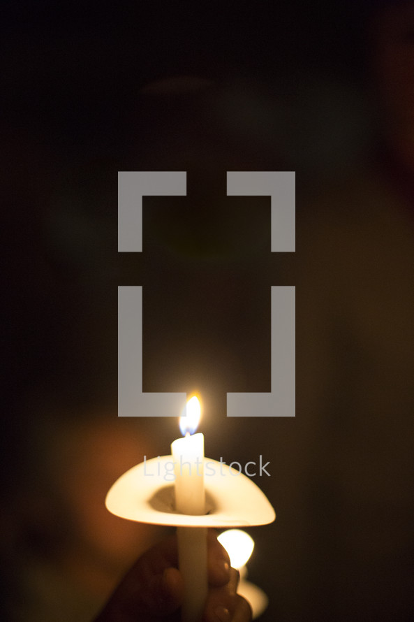 person holding a candle at a candlelight service 