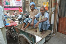 two men sitting in a pedicab wagon
