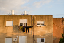 clothes on a clothesline in front of an apartment window 