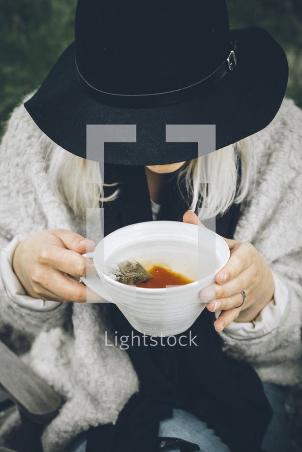 a woman holding a mug of tea 