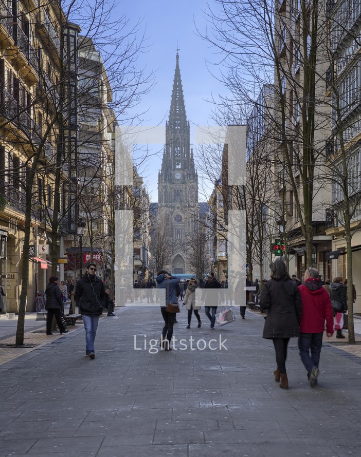 pedestrians in a city and view of a cathedral 