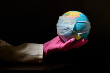 arm holding out a globe with a mask 