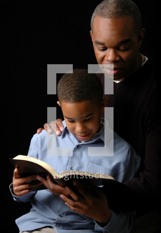 Father reading a Bible to his son