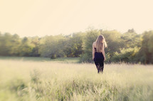 woman in a black dress walking in a field