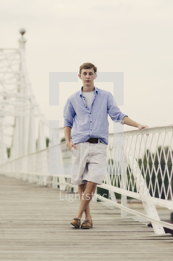 teen boy posing on a white bridge 