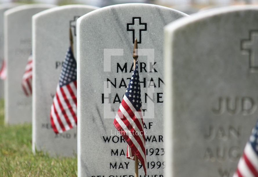 American flags in front of grave markers 