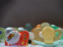 a bunch of pacifiers, 
pacifier, dummy, comforter, baby, toodler, child, little, soother, lost, family, children, kid, kids, new, newborn, young, pacifiers, care, calm, soothe, lull, reassure, comfort, smooth, pacify, quiet, lot, bunch, cluster