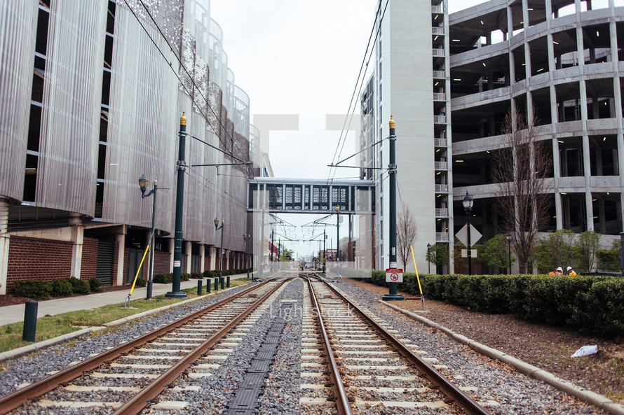 Railroad tracks in between two office buildings.