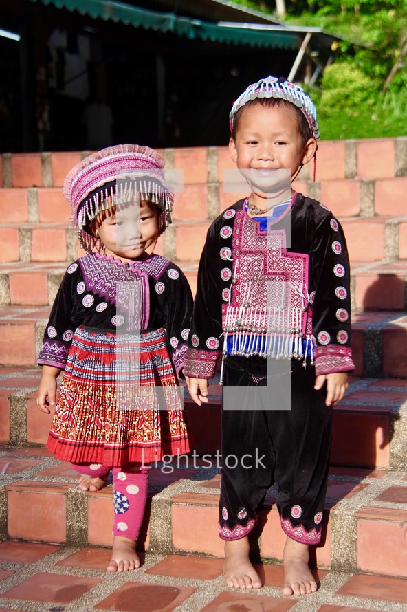 toddlers in traditional clothing holding hands 