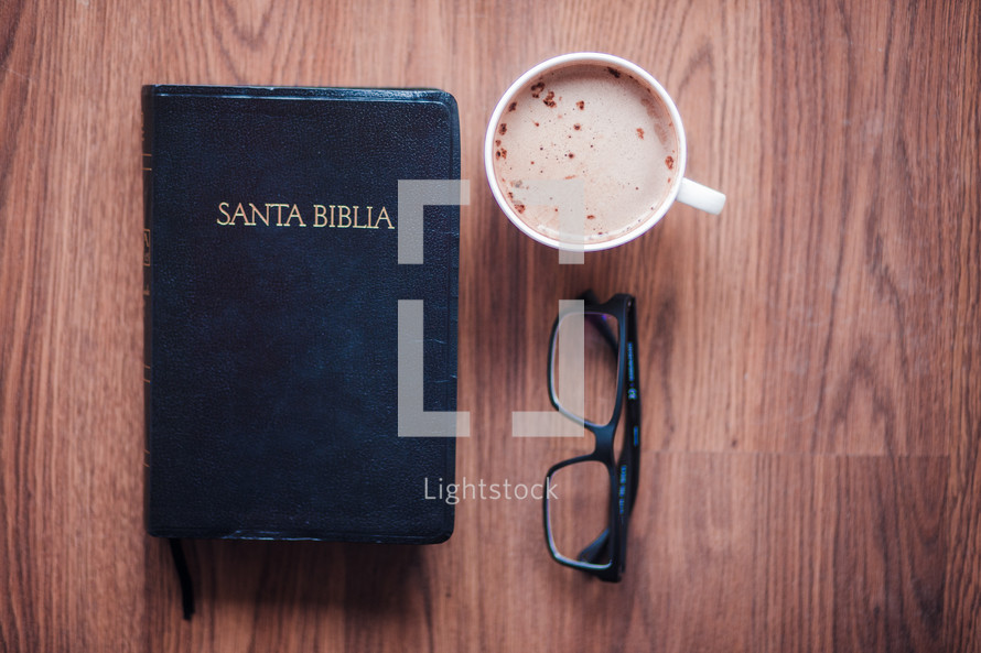 Santa Biblia, reading glasses, and cappuccino 