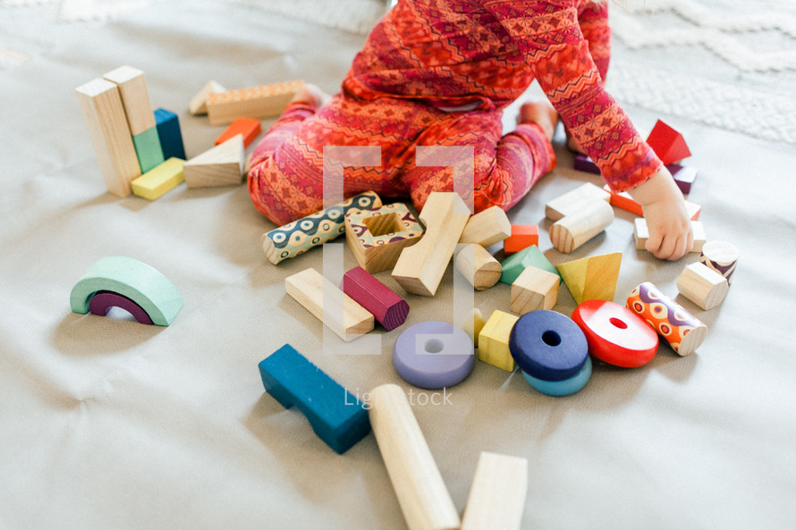 toddler girl playing with building blocks 