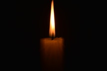 A candle burning in the darkness