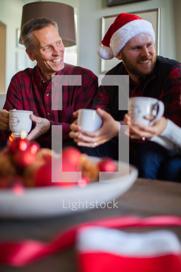 Two men sitting on a couch at a Christmas party