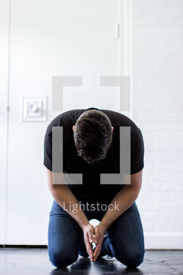 a man kneeling in prayer 