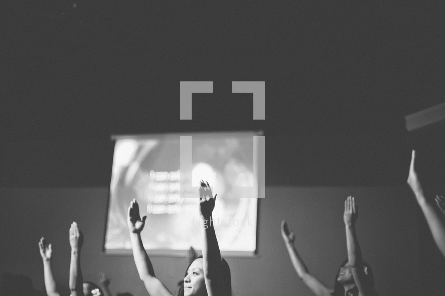 Hands raised in worship at a worship service. 