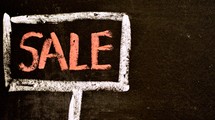 A chalk drawing of a sale sign.