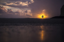 silhouettes of a couple on a beach at sunset 
