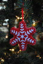 red snowflake ornament on a Christmas tree 
