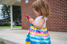 a toddler girl playing with a cellphone 