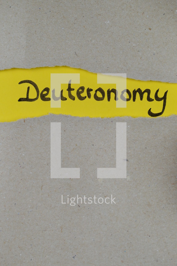 Deuteronomy - torn open kraft paper over yellow paper with the name of the book Deuteronomy