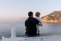 Father and son looking out over sea