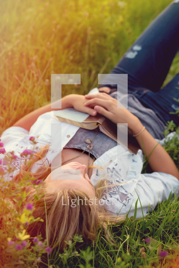 Woman laying in a field of grass.